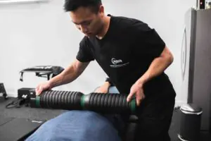 Patient working with a provider at a performance physical therapy clinic in Torrance, CA during a lower extremity rehabilitation session
